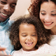 Two parents reading a book with their child.